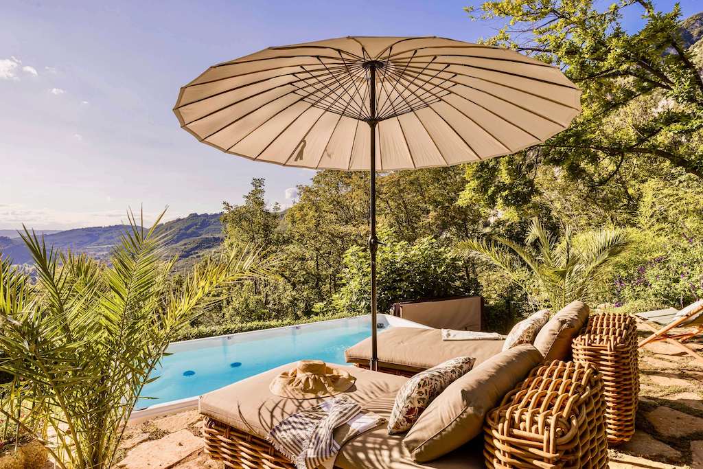 Sun loungers and parasol by a pool